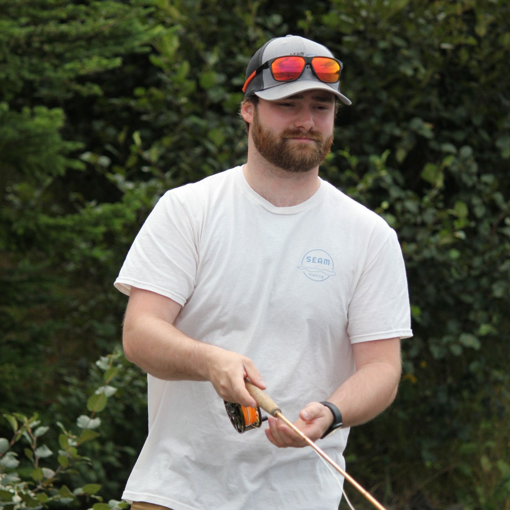 Man holding a fishing rod with a natural background (global).